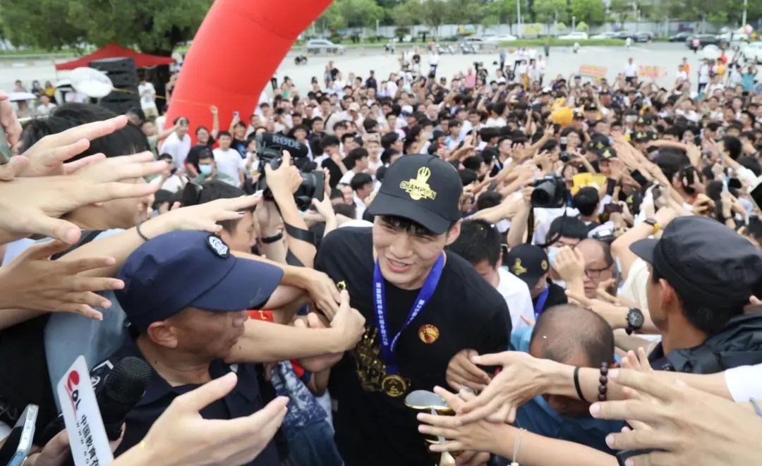 数千名师生在华亿体育（中国）游戏平台大学城正门口迎接篮球队凯旋。